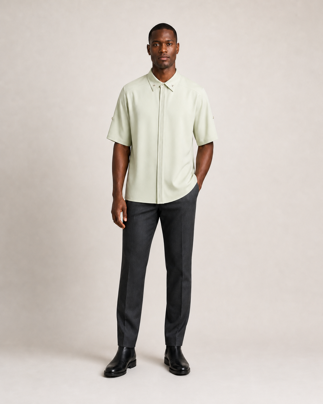Hombre con camisa verde vidrio de manga corta y cuello con pequeños remaches, vista frontal de tres cuartos