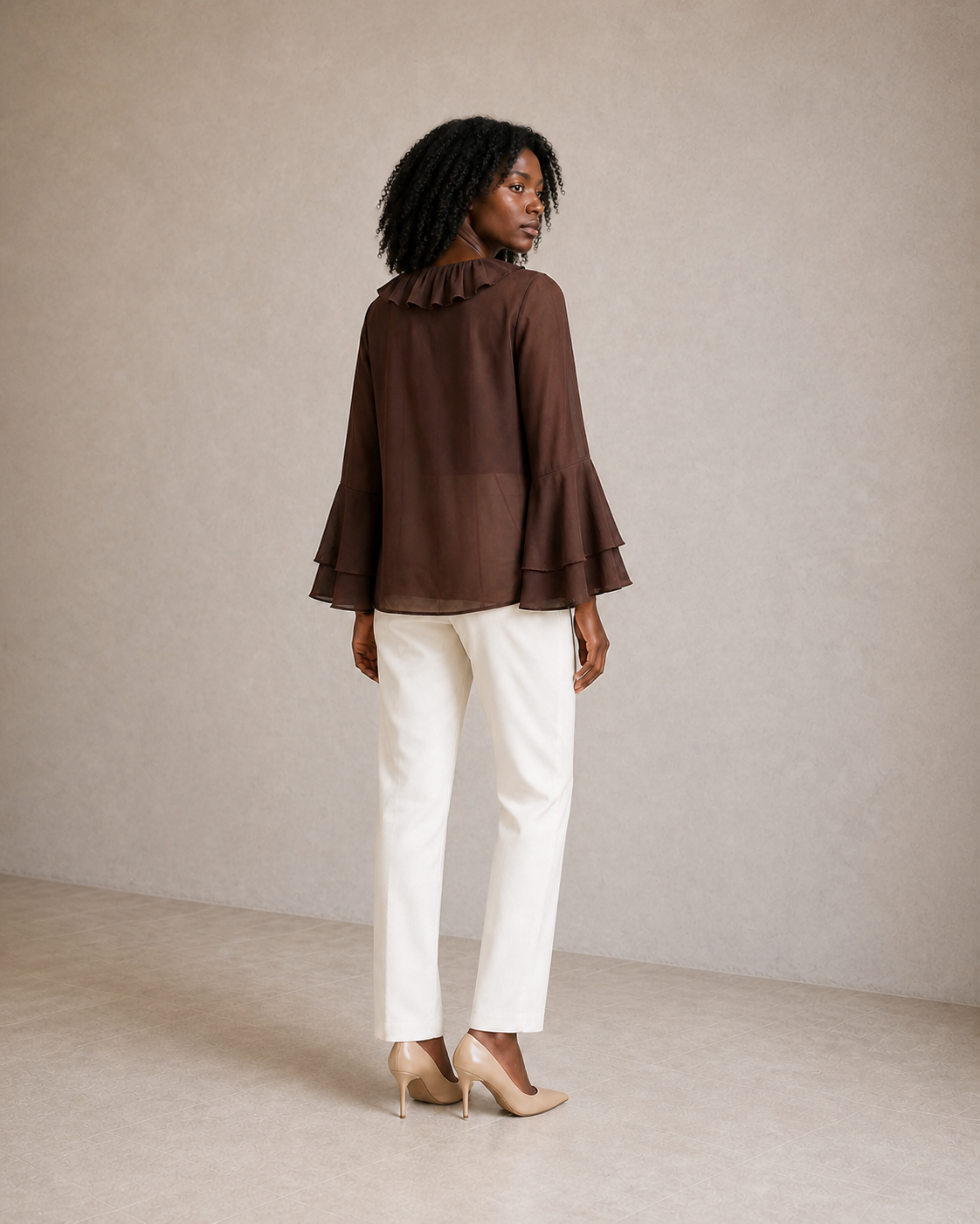 Modelo con blusa marrón café de volantes, vista posterior tres cuartos