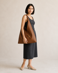 Mujer con bolso hobo marrón de gran formato llevado en la mano