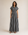 Mujer con vestido camisero largo de rayas blancas y negras, vista frontal de cuerpo entero