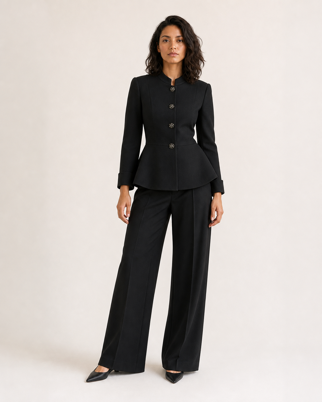 Mujer con blazer peplum negro de cuatro botones, vista frontal dominante en movimiento