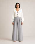 Mujer con cárdigan corto blanco de tres botones y pantalón gris, vista frontal de cuerpo entero