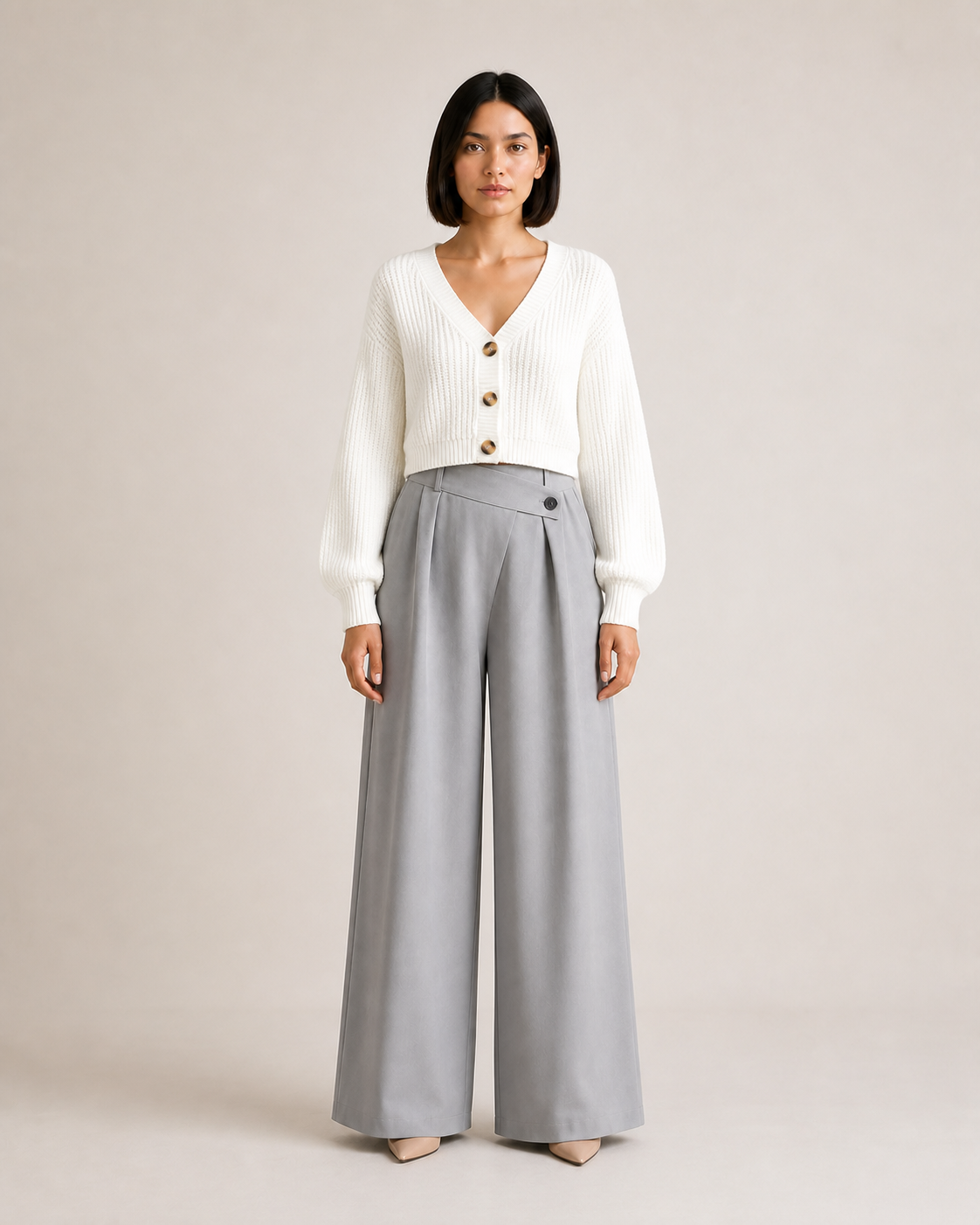 Mujer con cárdigan corto blanco de tres botones y pantalón gris, vista frontal de cuerpo entero